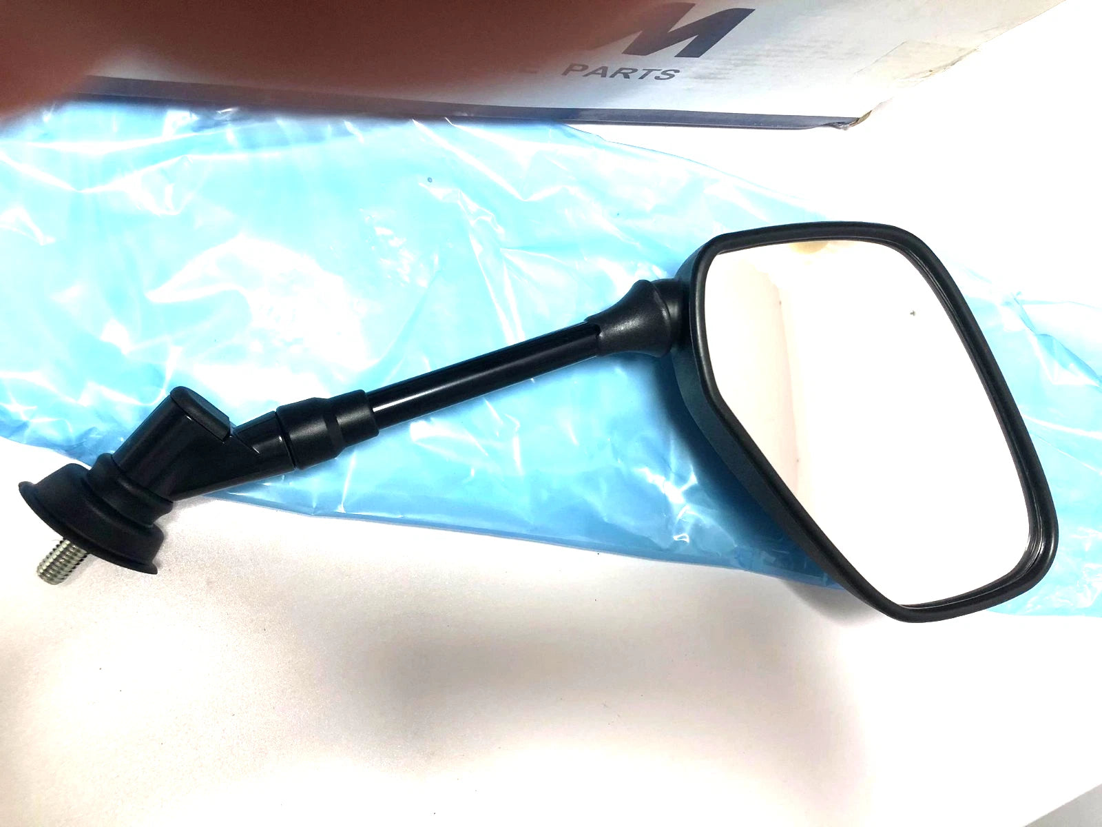Black rectangular mirror with dual-sided view mounted on a blue plastic packaging labeled “nos Sym CITYCOM 300 RH.”